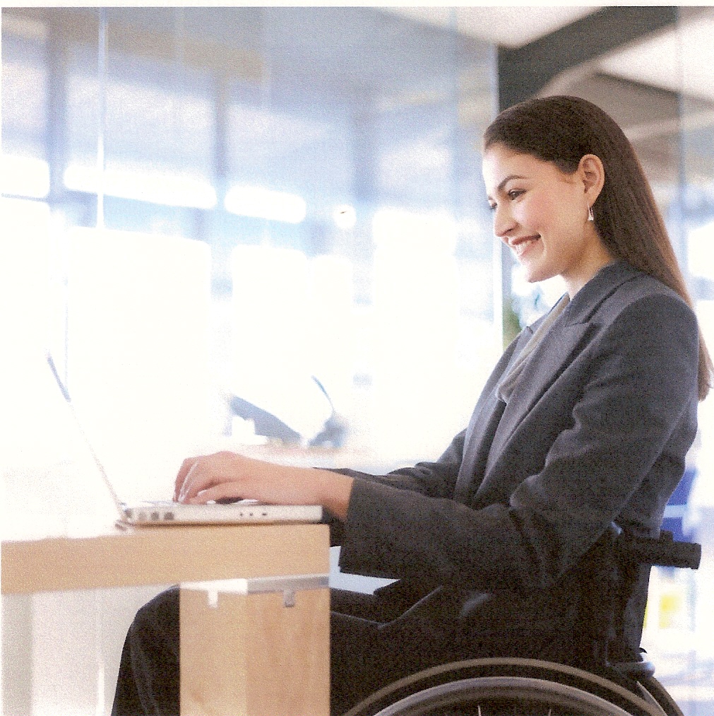 Woman working on a computer sitting in a wheelchair